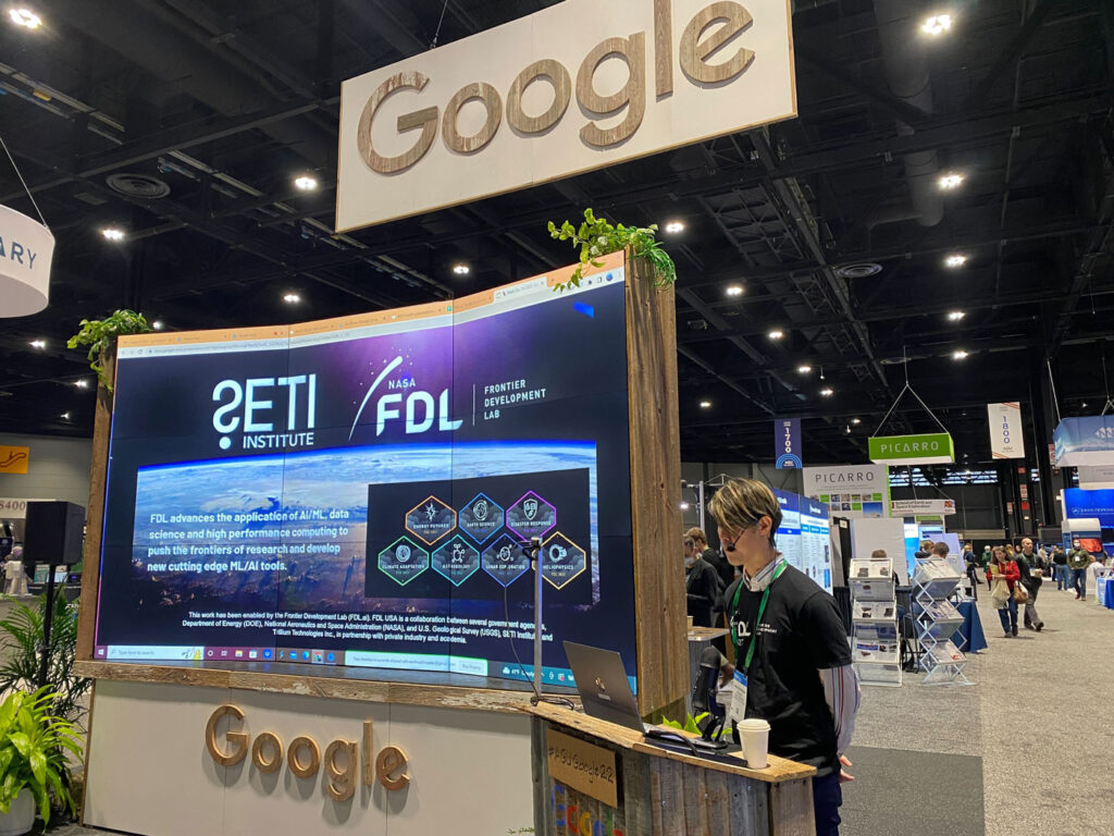 image of an FDL Researcher making a presentation at a Google Booth at a conference